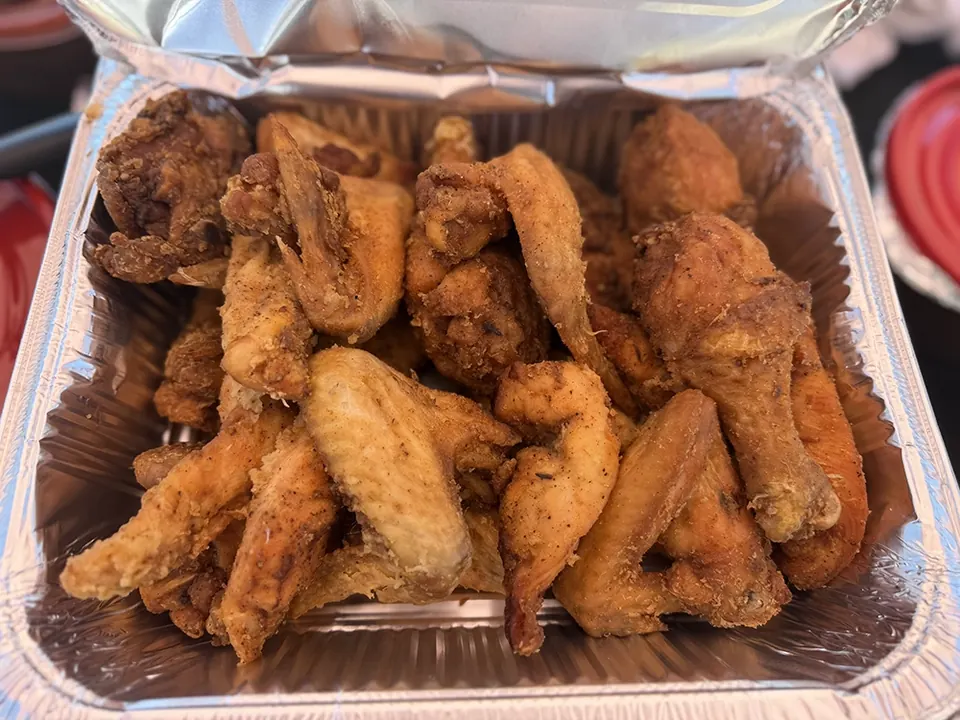A catering pan filled with golden chicken wings