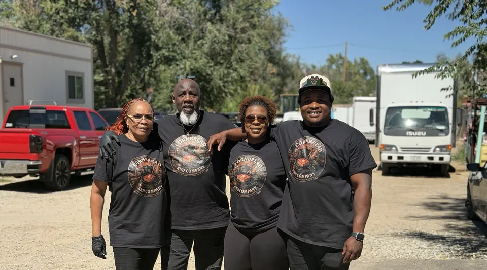 Four Cornbread & Company team members standing together outside in branded shirts
