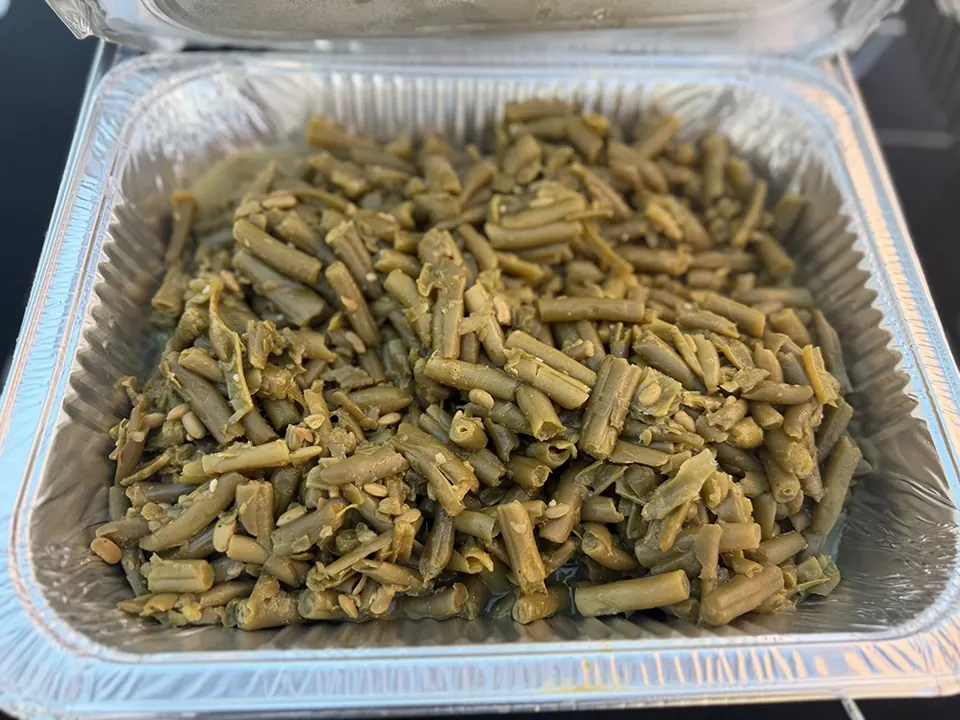 A catering pan filled with cooked green beans