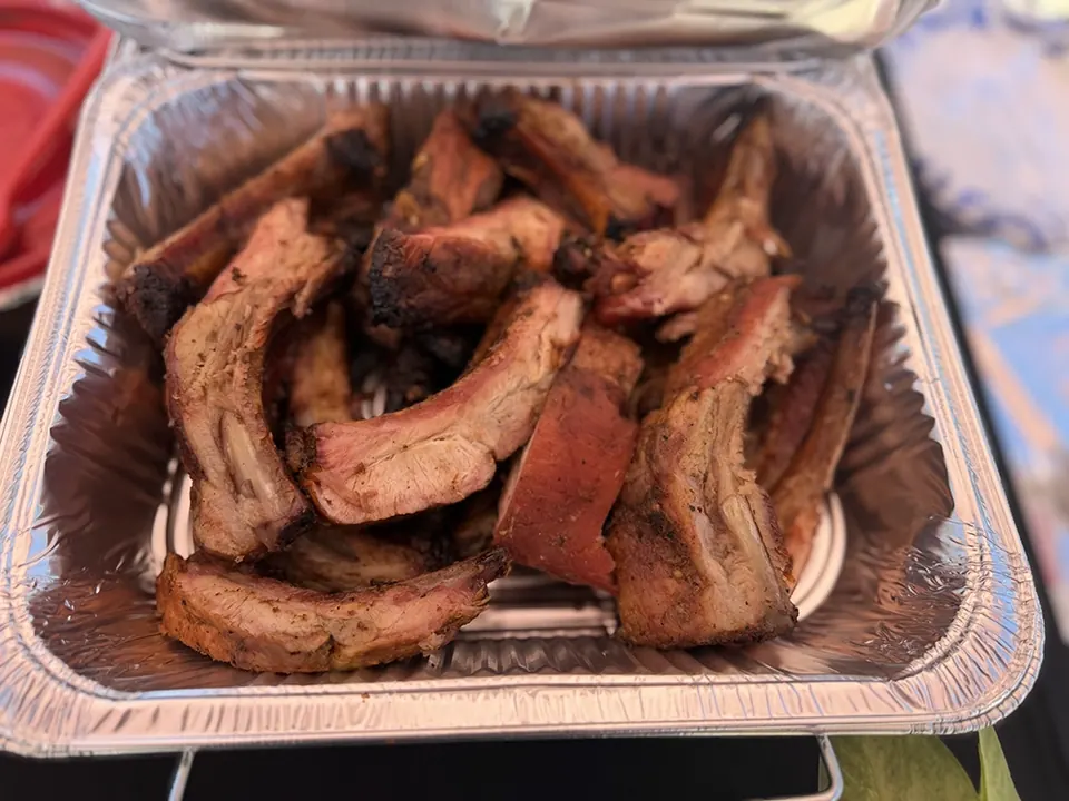 Sliced ribs arranged in a foil catering pan