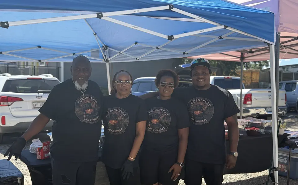 Four Cornbread & Company team members standing under an outdoor canopy